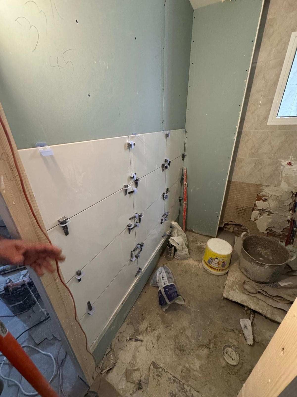 Una habitación en proceso de renovación que muestra azulejos