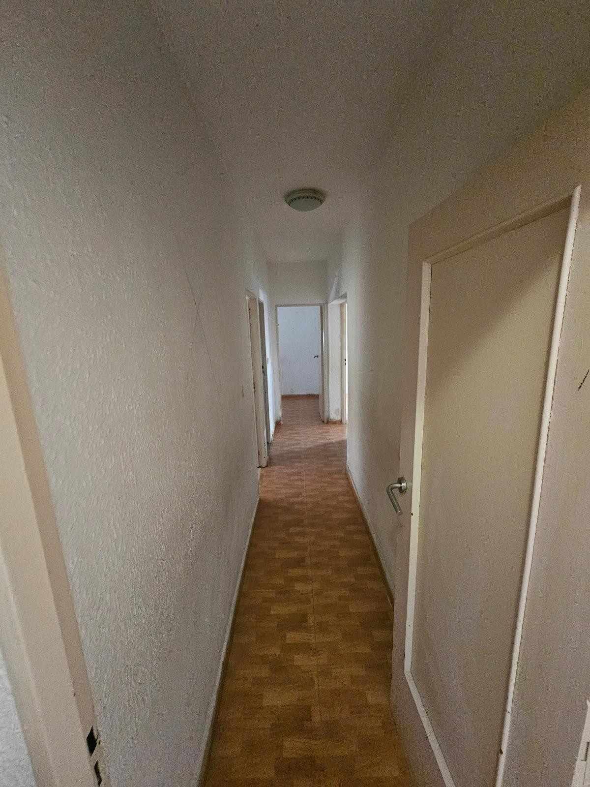 Un pasillo estrecho con paredes de color claro