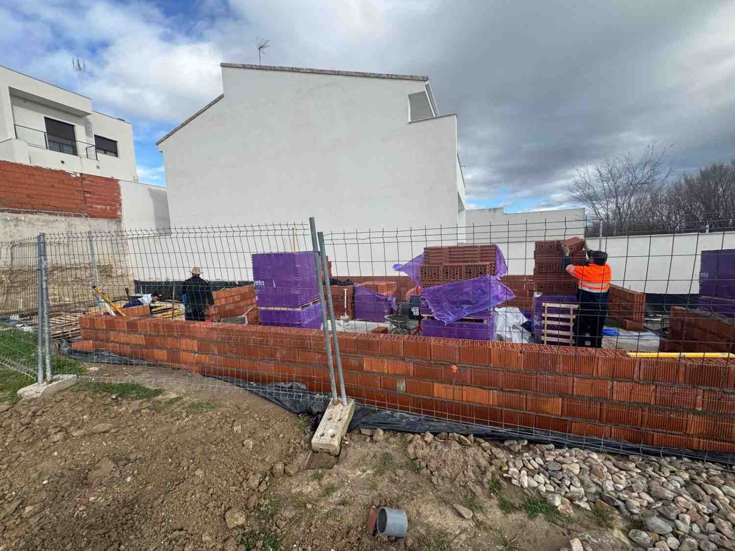 Obrero de la construcción inspeccionando una pared de bloques de hormigón
