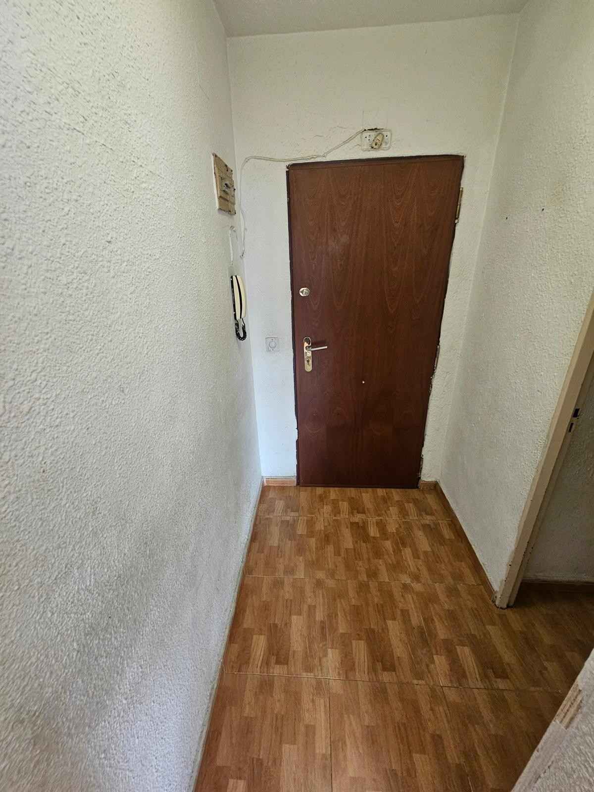 Un pasillo interior estrecho con paredes blancas texturizadas