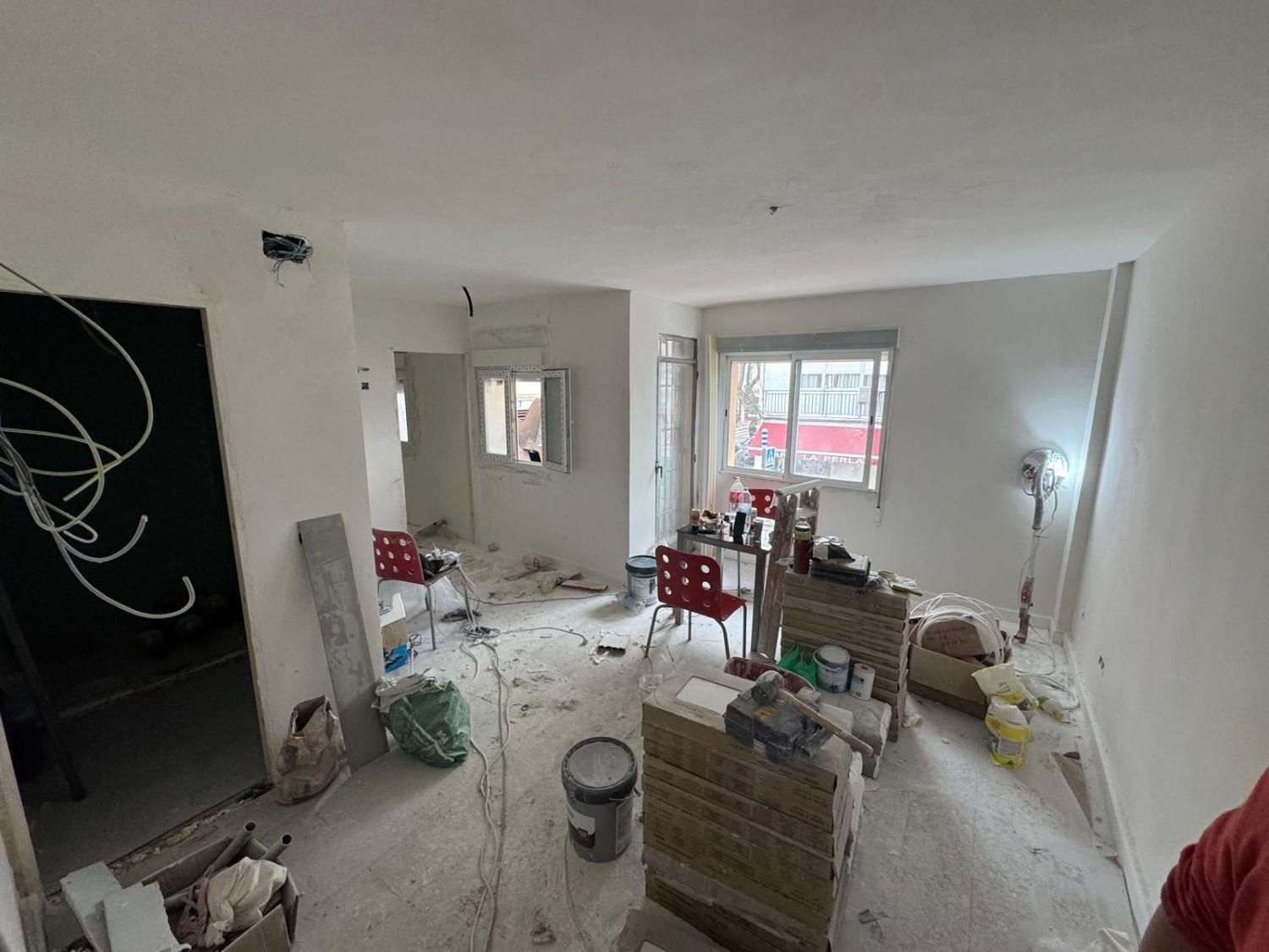 Una habitación en proceso de renovación con paredes blancas