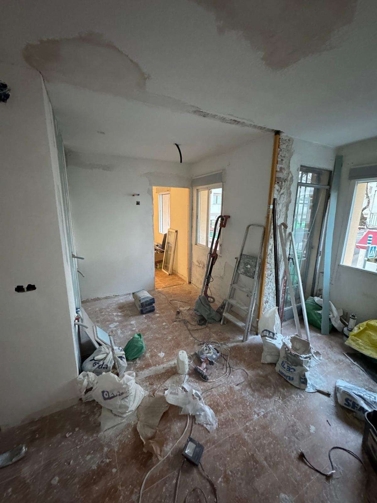 Una habitación en obras con las paredes a la vista, escombros de la construcción