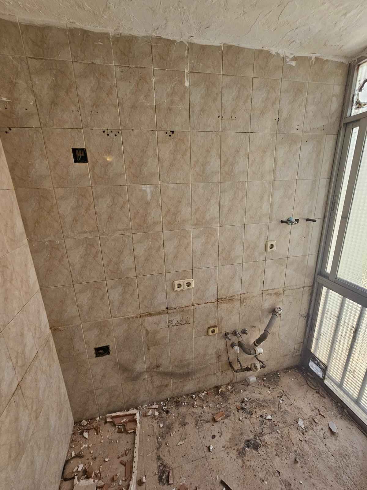 Una pared en construcción con azulejos de color claro