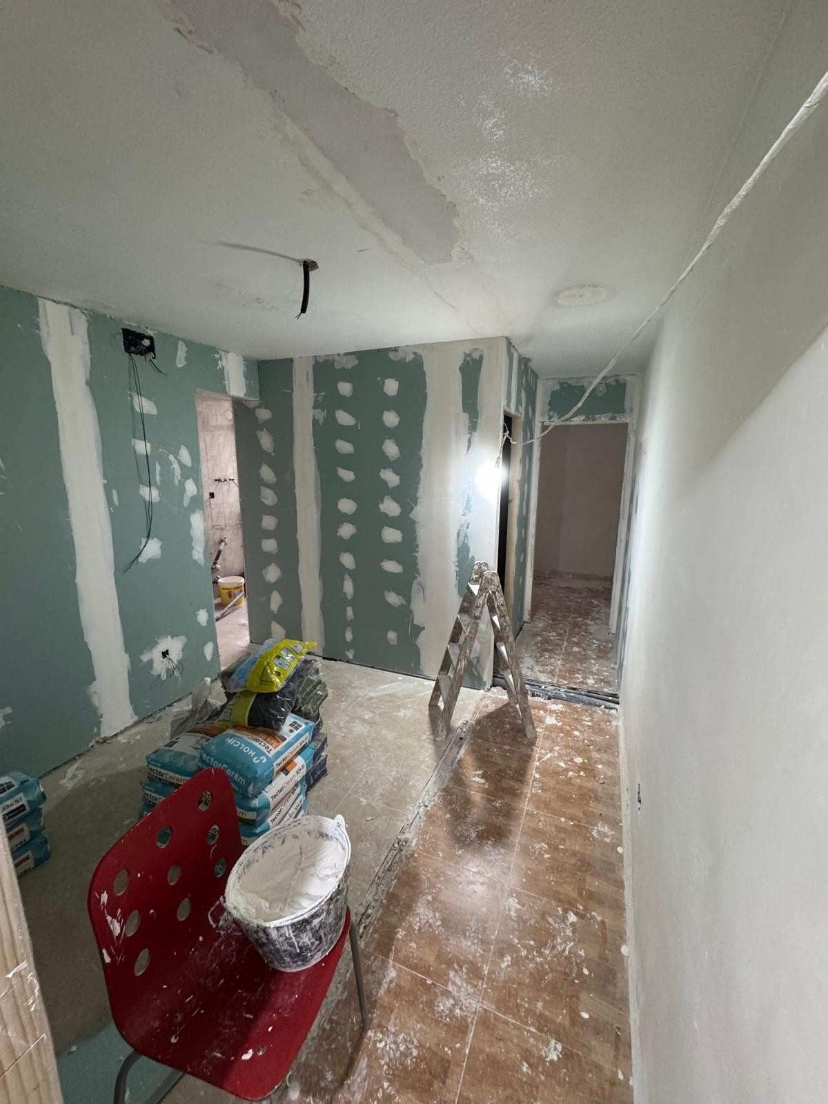 Obra en construcción en un pasillo con paneles de yeso verdess