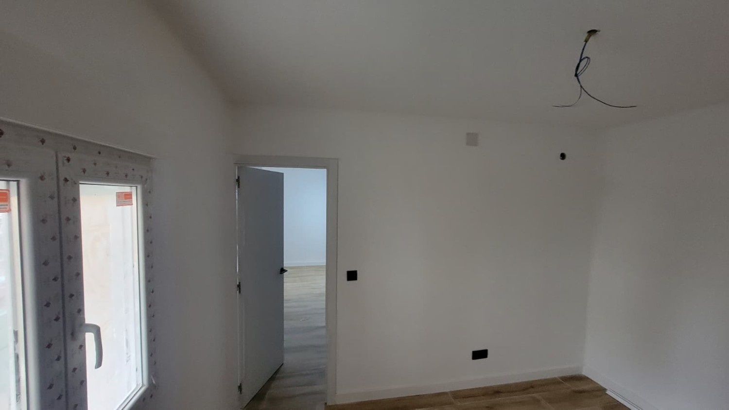 Una habitación luminosa y vacía con paredes blancas