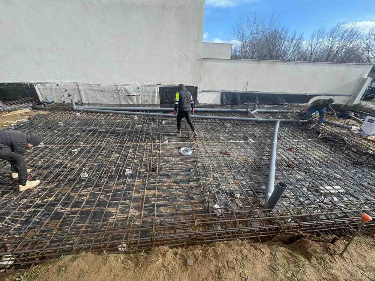 Persona con casco sosteniendo un controlador de dron en un sitio de construcción.