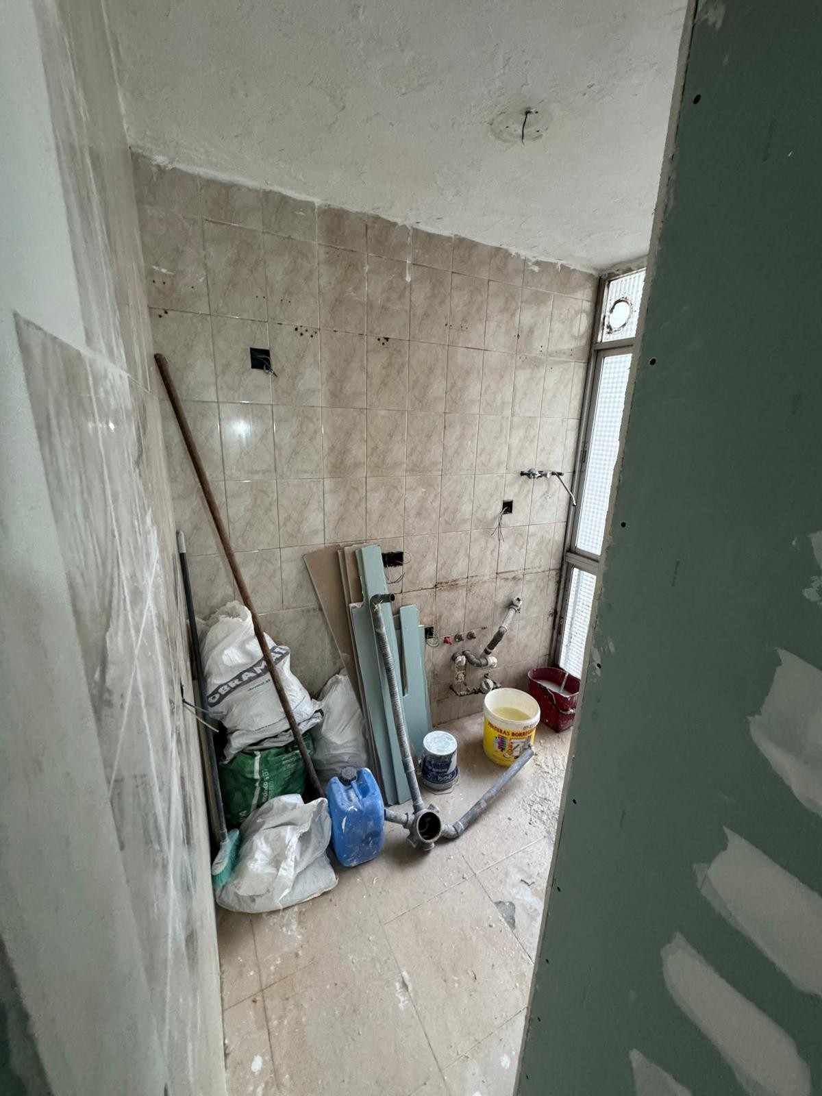 Primer plano de un panel eléctrico con una mano utilizando una herramienta cerca de disyuntores y cables.