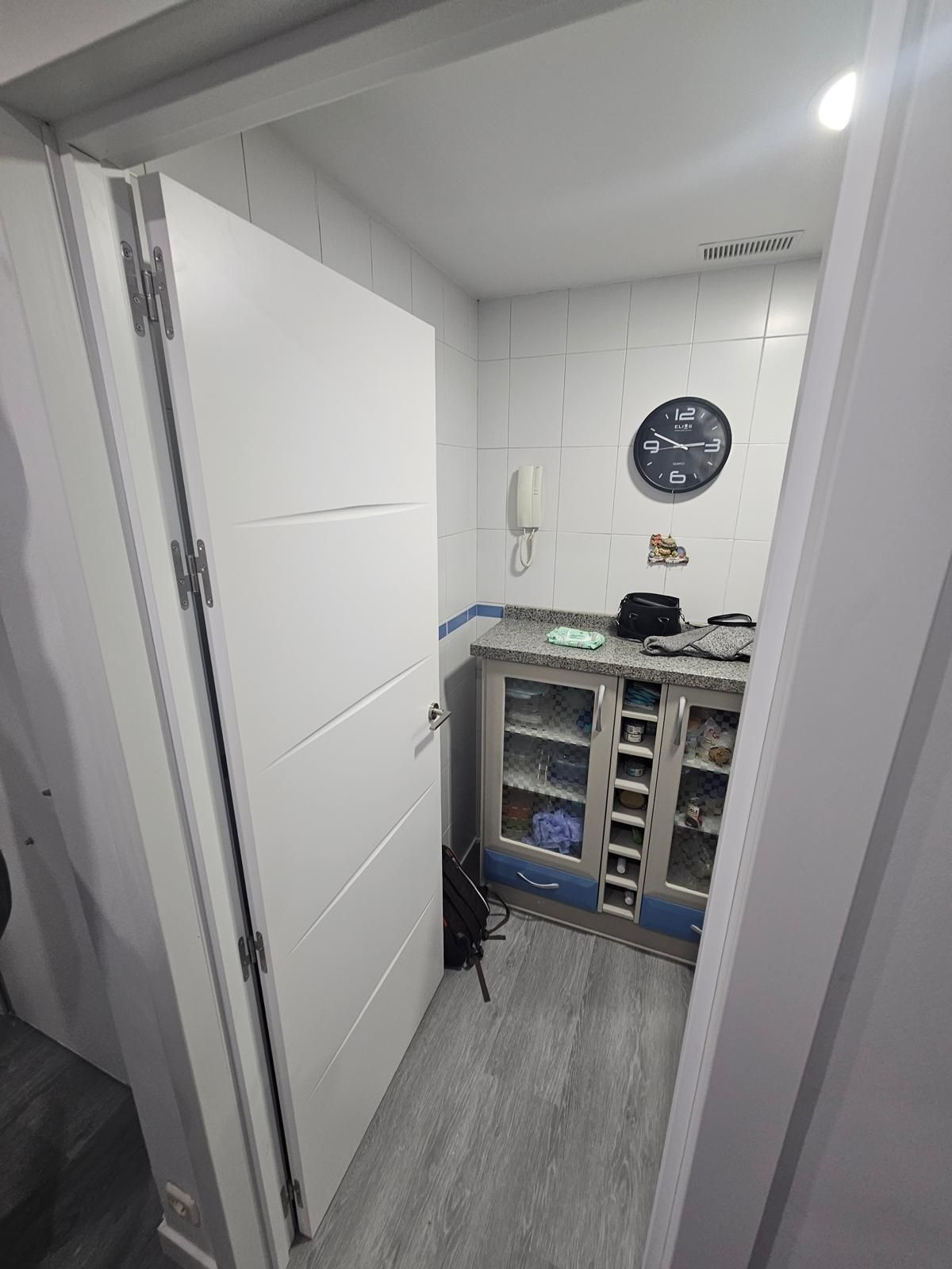 Persona con equipo de protección pulverizando pintura en un interior.