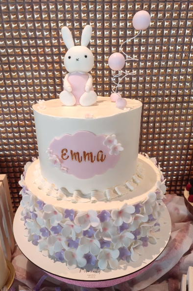 Un pastel de cumpleaños para Emma con un conejito encima.