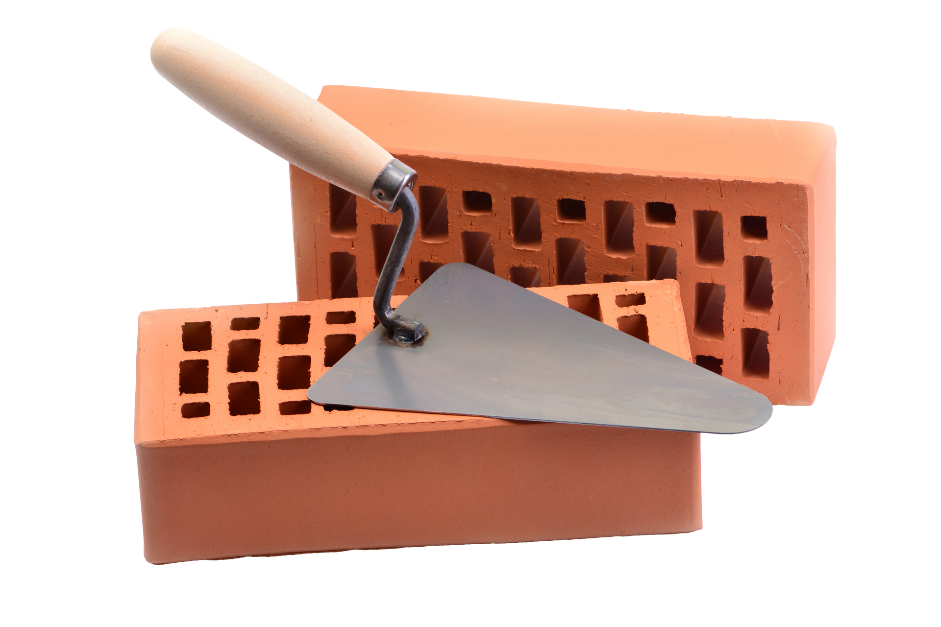 Brique et truelle pour la construction. Deux briques rouges percées et une truelle en métal à manche en bois.