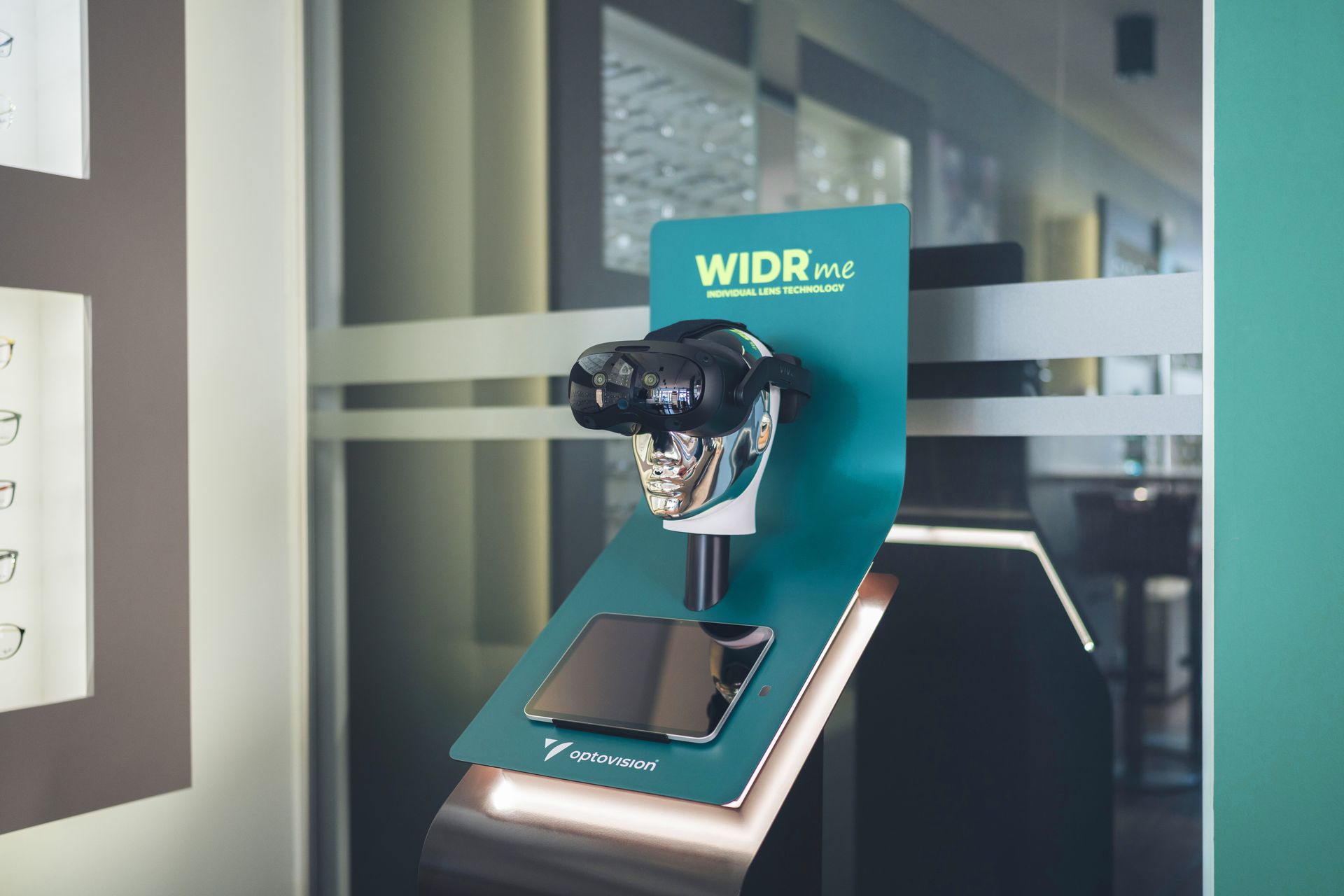 Ausstellungsständer mit VR-Headset, Smartphone und „WIDR mtl“-Logo. Türkis und Silber, für den Einsatz im Laden.