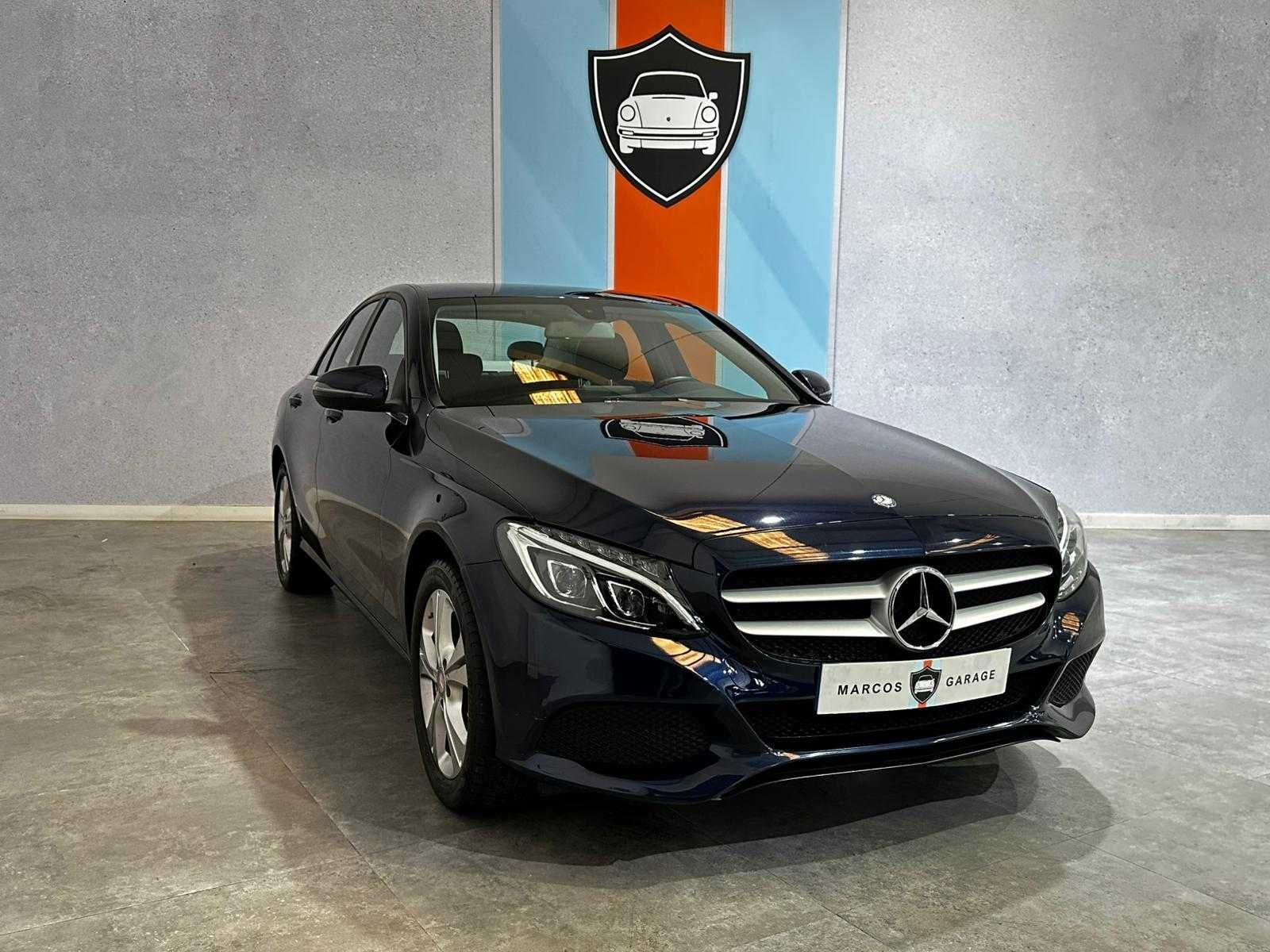Un Mercedes Benz Clase C azul está estacionado en una sala de exposición.