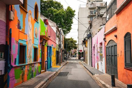 La Casa Rosada, un histórico edificio gubernamental de color rosa en Buenos Aires, se alza bajo un cielo azul despejado con la bandera argentina.