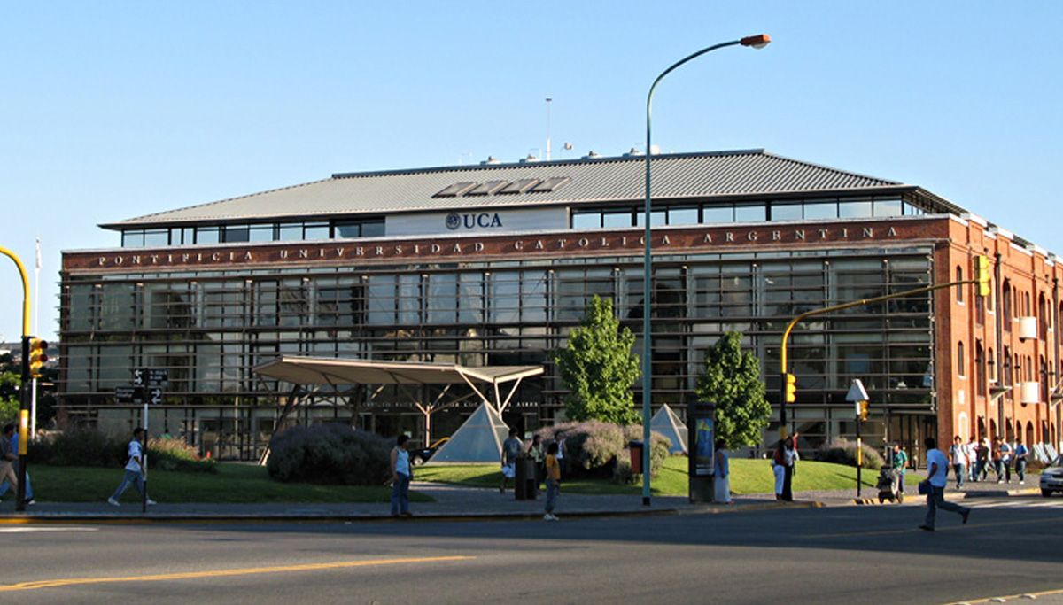 Cúpula del planetario iluminada.  Árboles y césped en primer plano. Escena nocturna.