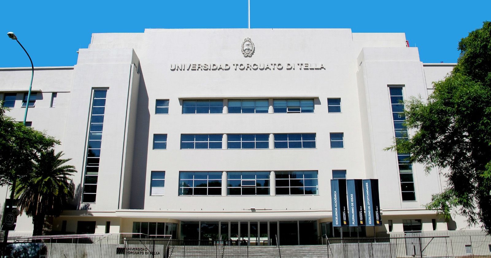 Interior de museo moderno, paredes blancas y exterior de cristal. Una persona se encuentra en la planta baja.