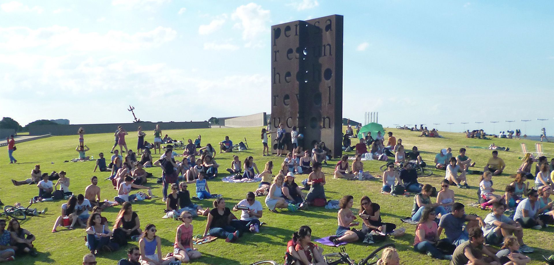 Cúpula del planetario iluminada.  Árboles y césped en primer plano. Escena nocturna.