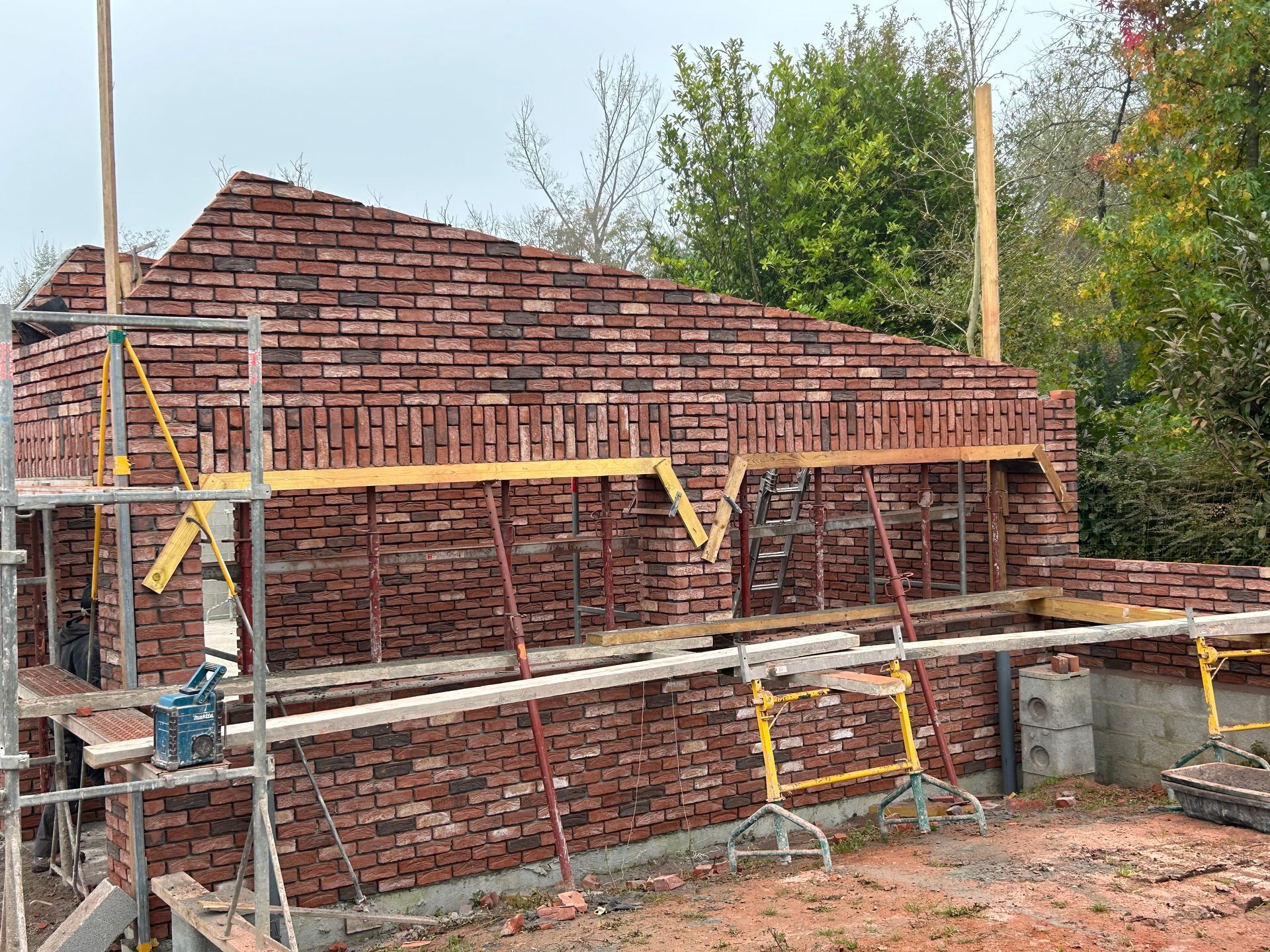 Bâtiment en briques en construction, avec des échafaudages.