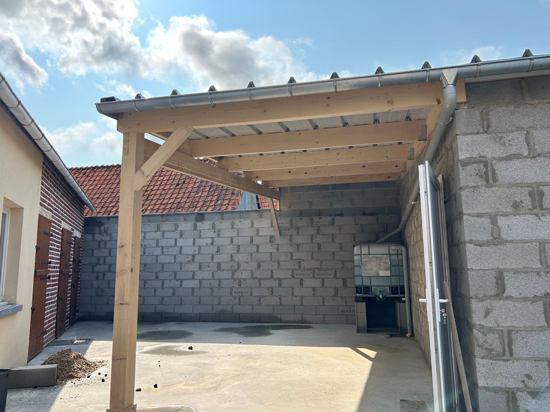 Création d'un carport le long d'un mur en parpaings.