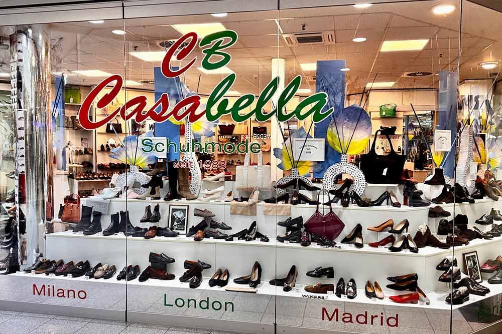 Schuhladenauslage, „CB Casabella“. Schuhe in Regalen, Aufschrift „Mailand“, „London“, „Madrid“.