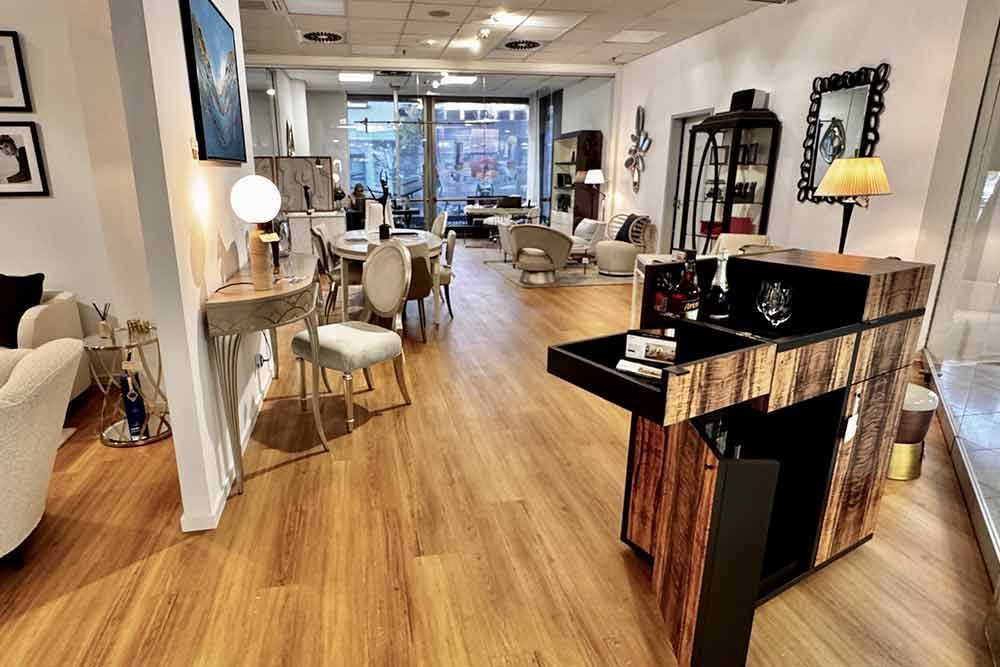 Innenansicht eines Möbelgeschäfts mit Holzböden und verschiedenen Auslagen von Möbeln und Dekorationsartikeln.