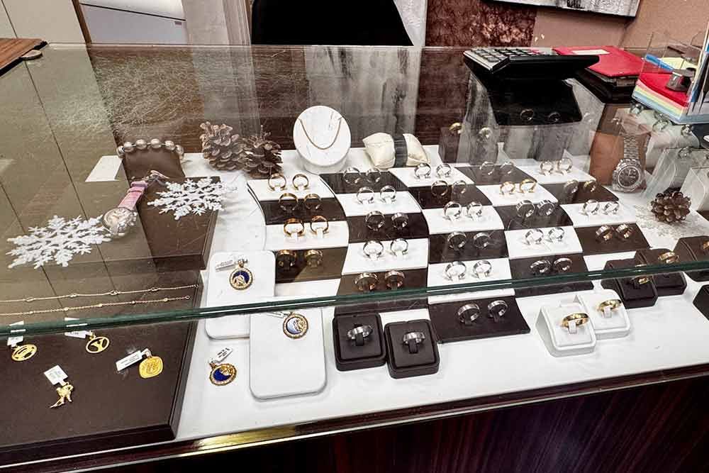 Schmuckvitrine mit Ringen, Halsketten und Ohrringen, beleuchtet mit natürlichem Licht.