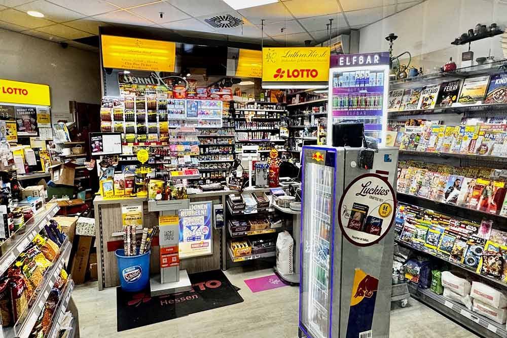 Innenansicht eines kleinen Lebensmittelladens, gut sortiert mit Snacks, Zeitschriften und Lottoscheinen.