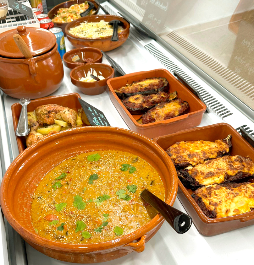 Una vitrina llena de tazones de comida, incluido un tazón de sopa.