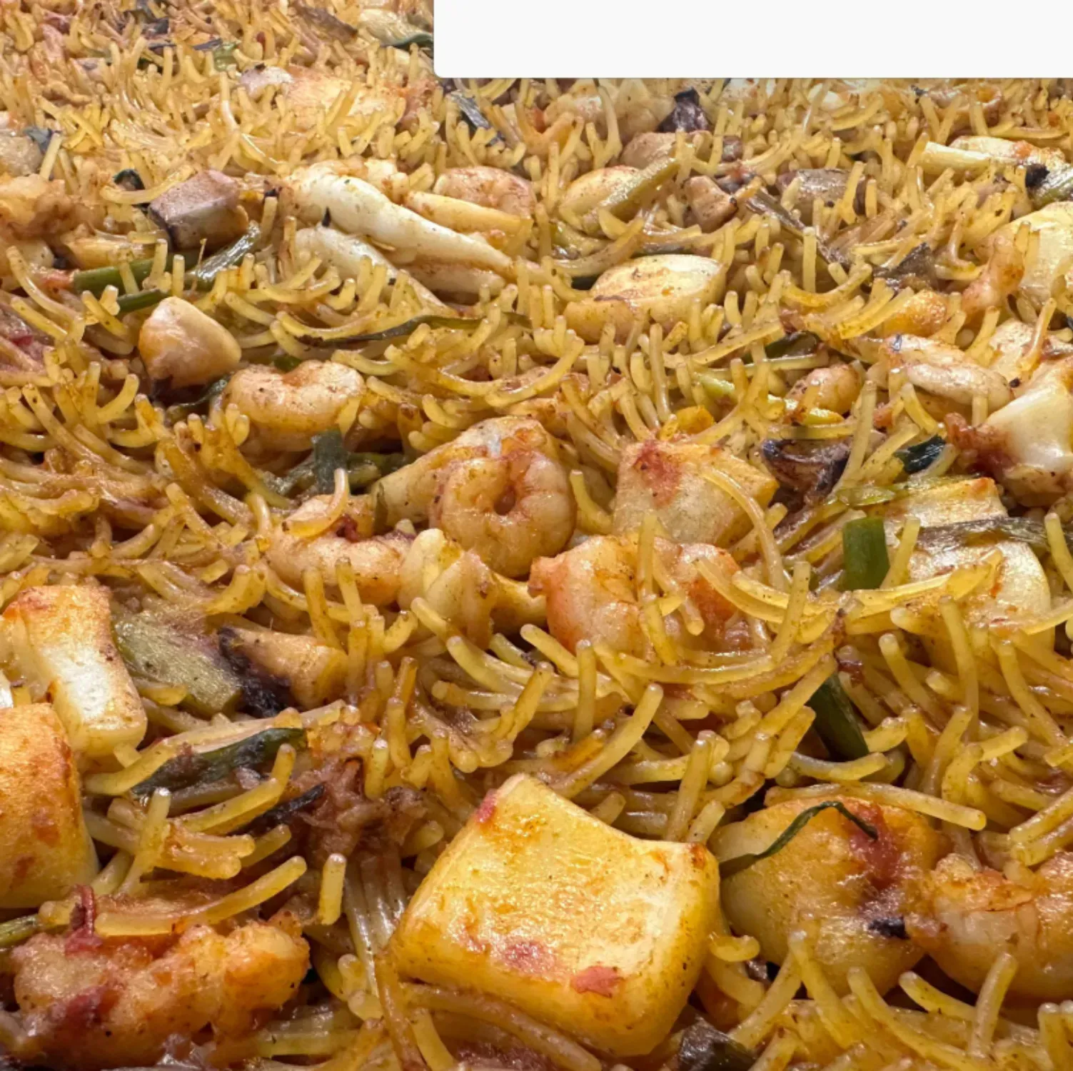 Un primer plano de un plato de arroz con camarones y patatas.