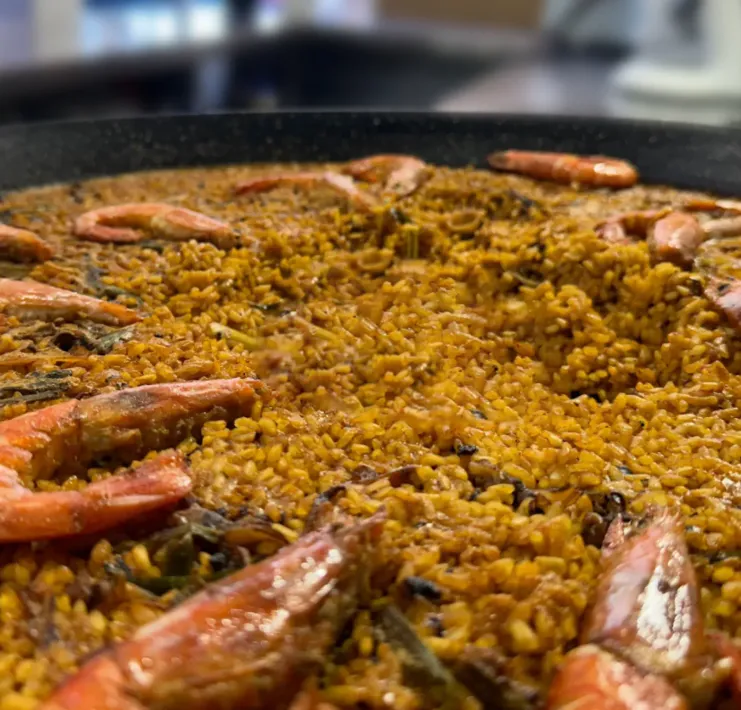 Un primer plano de una sartén con arroz y camarones.