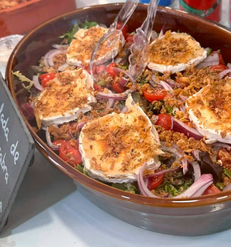 Un cuenco de comida con pinzas junto a un cartel que dice