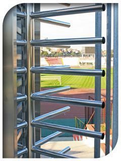 Un torniquete de acero inoxidable con vista a un campo detrás de él.
