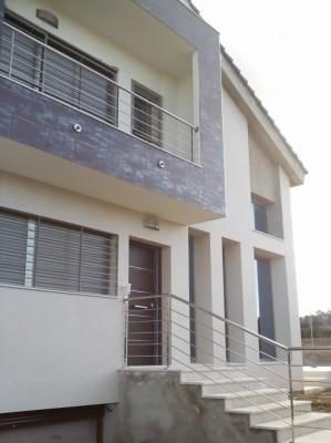 Una casa blanca con balcón y escaleras