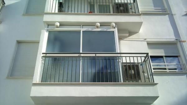 Un balcón en el costado de un edificio blanco.