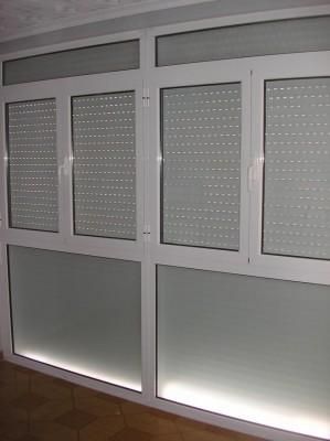 Una habitación con muchas ventanas y persianas.