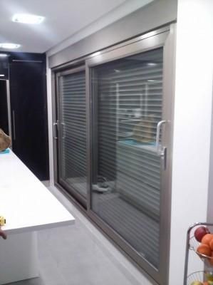 Una cocina con puerta corrediza de vidrio y persianas.