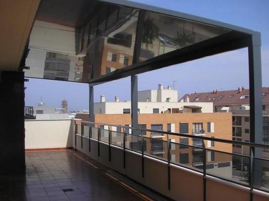 Un balcón con un reflejo de edificios en el cristal.