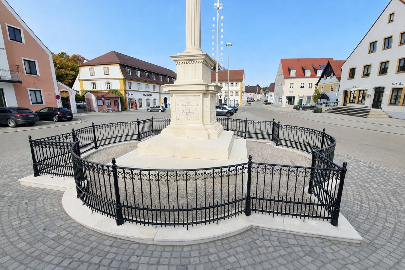 Weiße Lagercontainer neben einem weißen Haus mit gepflasterter Auffahrt und grünen Büschen.