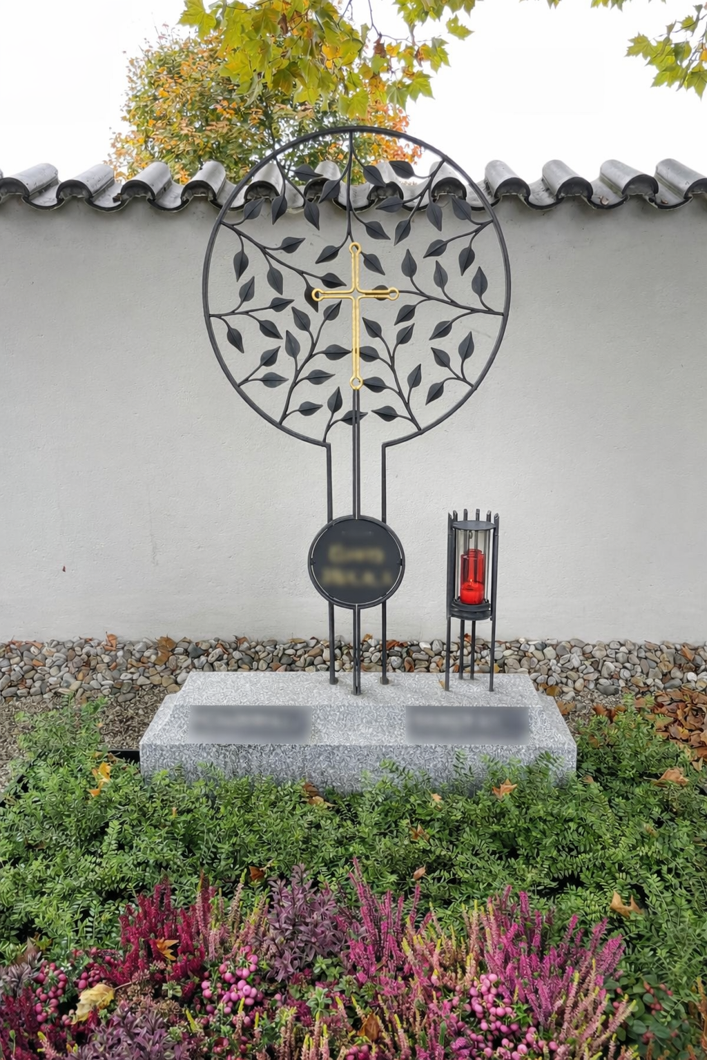 Dunkelgraues Metalltor mit Hausnummer 6 an einer weißen Wand.