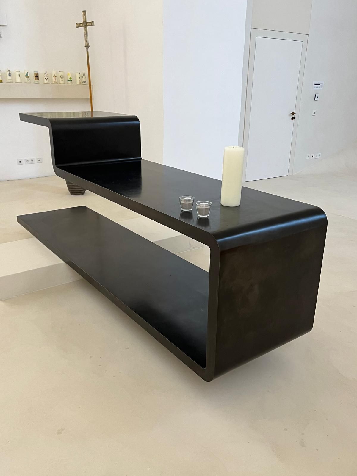 Treppe mit schmiedeeisernem Geländer, weißen Stufen und geschwungenem Design.