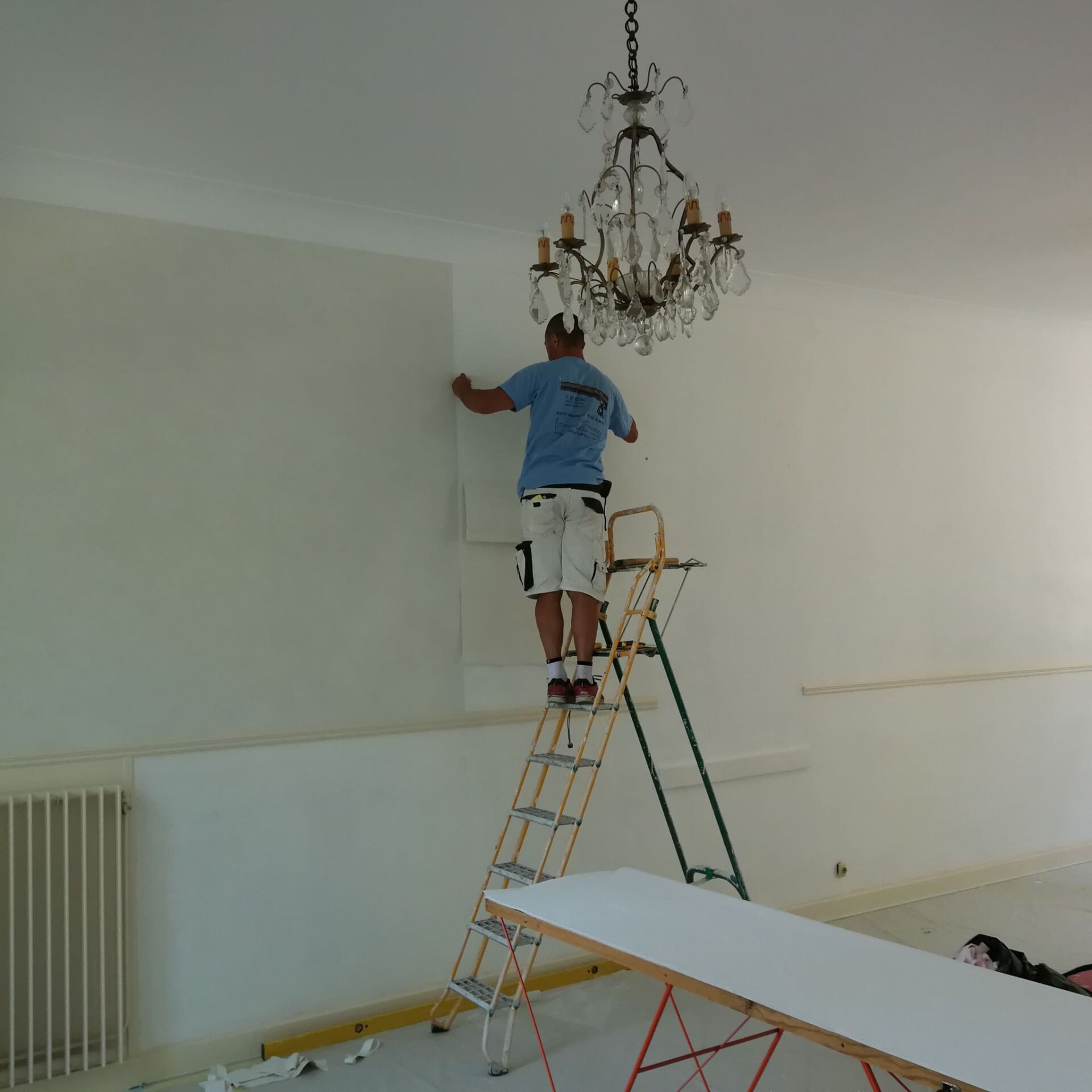 Un artisan d'AIX Toiture sur un escabeau