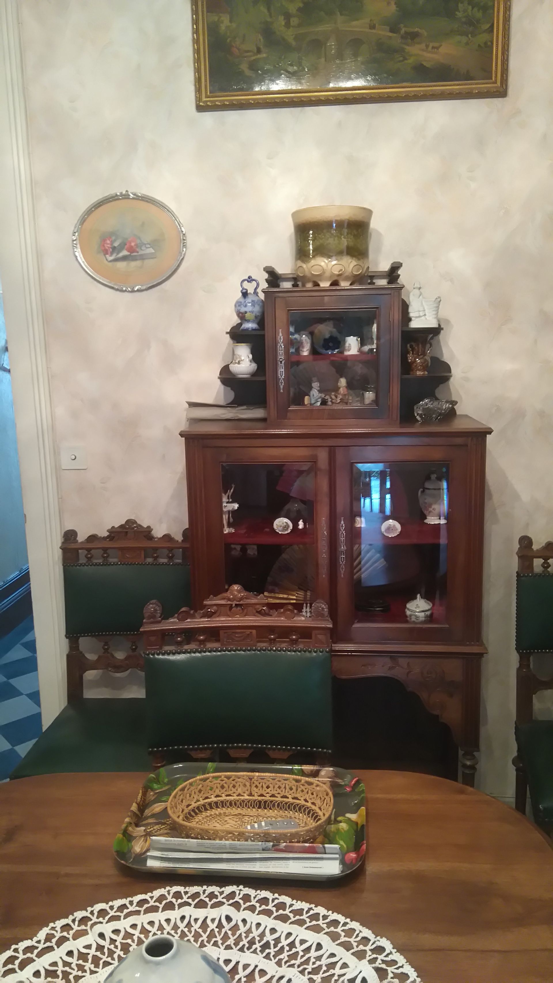 Vitrine en bois exposant des bibelots, avec une table et des chaises