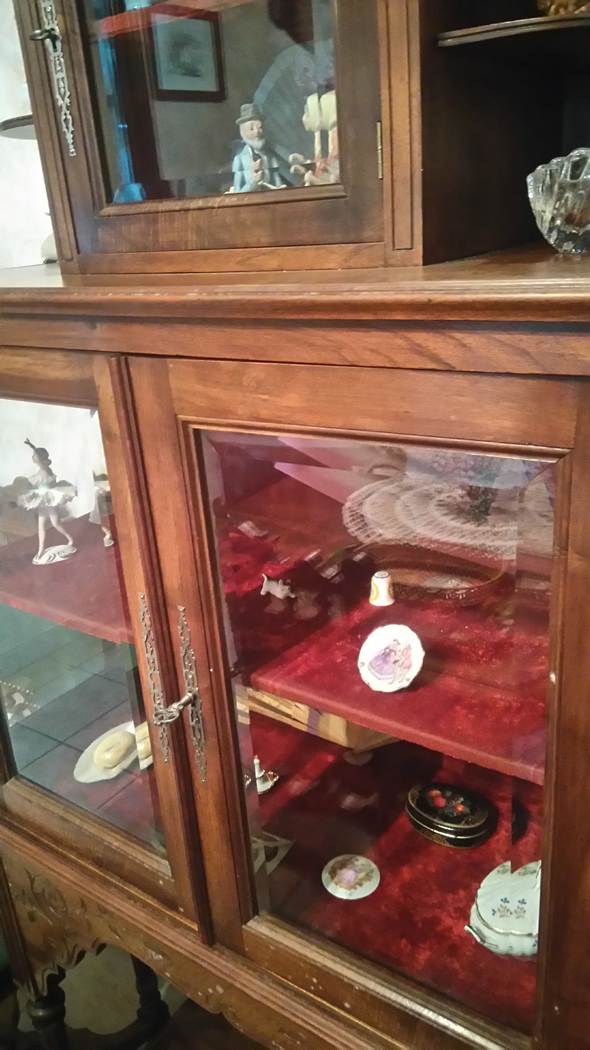 Vitrine en bois avec portes vitrées, intérieur en velours rouge et objets décoratifs