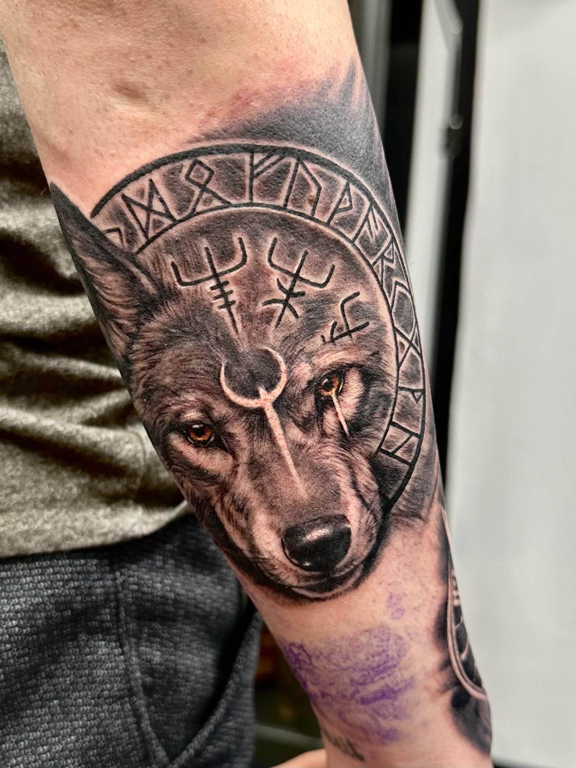 Tattoo eines Wolfes mit Vikinger Runen rechts