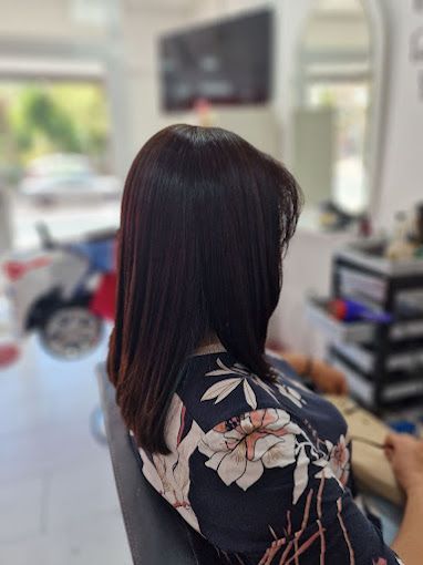 Una mujer está sentada en una silla de espaldas a la cámara.