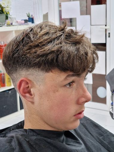 Un hombre con barba se está cortando el pelo en una barbería.