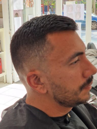 Un hombre con barba se está cortando el pelo en una barbería.