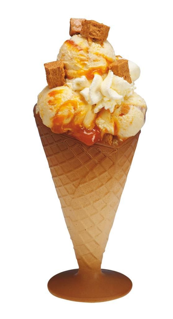 Cono de helado con llovizna de caramelo y trozos de cobertura.