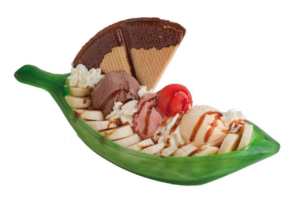 Banana split en un plato verde con forma de plátano, con bolas de helado, rodajas de plátano, crema batida y una oblea.