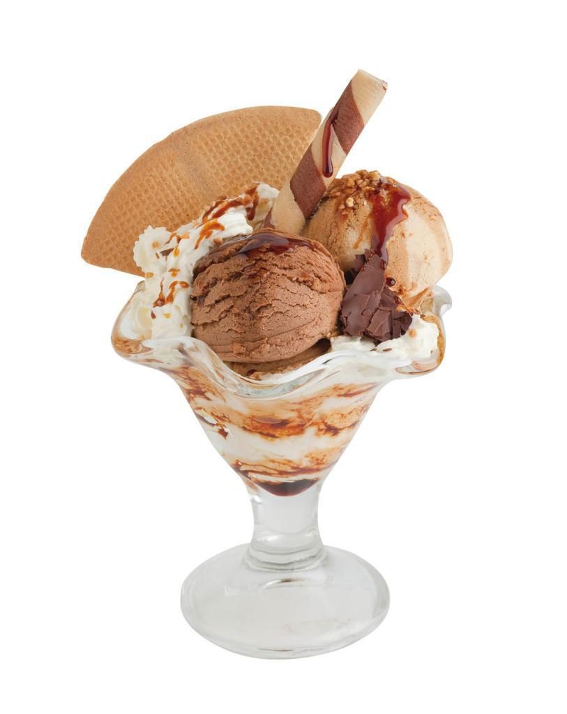 Sundae de helado en vaso, con bolas, aderezos y una oblea.