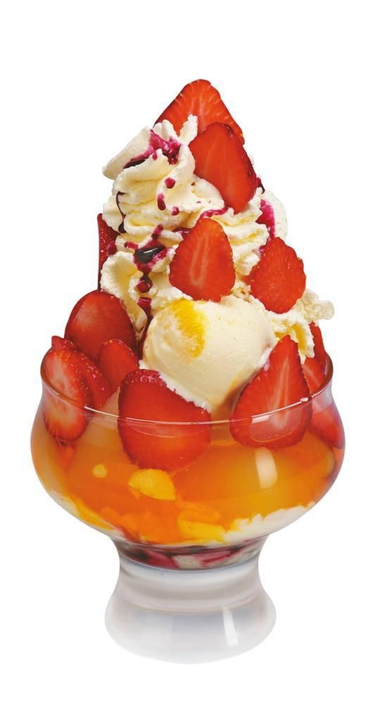 Sundae de fresa en copa, con crema batida, helado y cóctel de frutas.